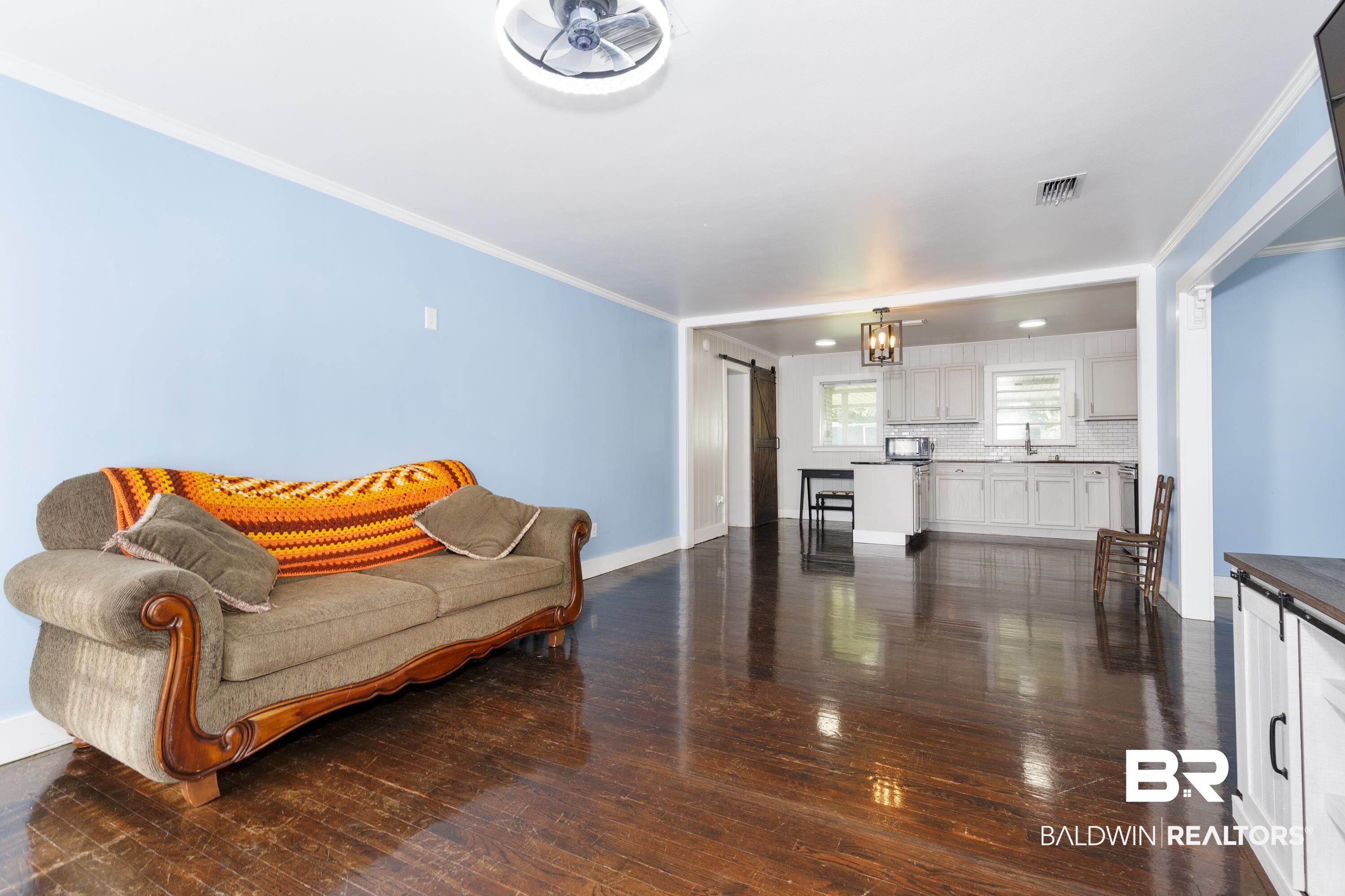 208 Beck Street Atmore, AL 36502 - Photo 10 of 26 Living area featuring dark wood-style floors and ornamental molding