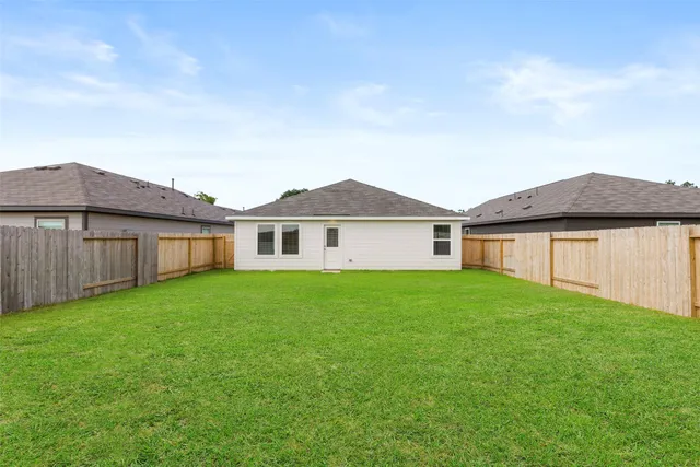 a view of a yard in front of a house with large trees