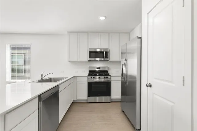 a kitchen with stainless steel appliances granite countertop a refrigerator and a sink