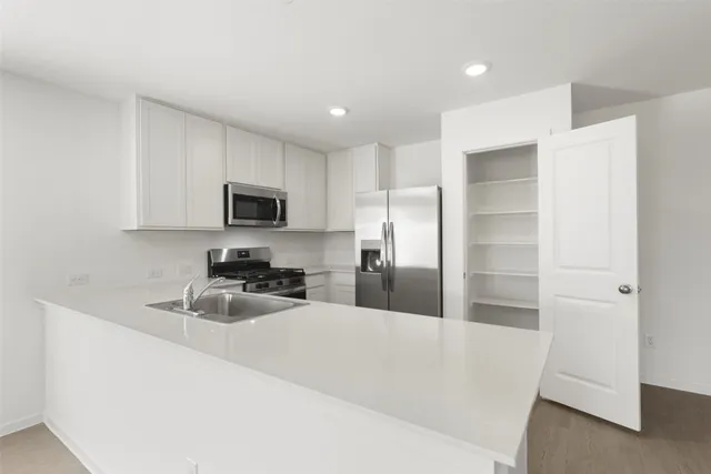 a kitchen with granite countertop a refrigerator and a sink