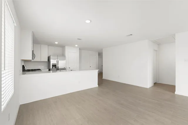 a view of kitchen with stainless steel appliances refrigerator stove microwave and cabinets
