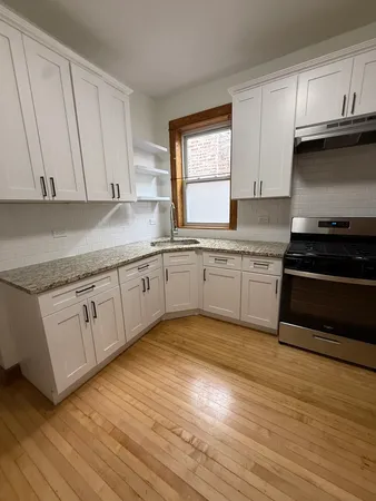 a kitchen with granite countertop a sink cabinets and stainless steel appliances