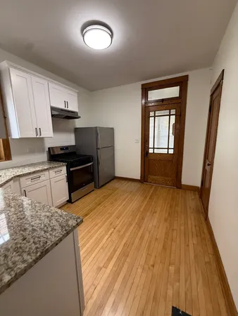 a kitchen with granite countertop wooden floors and white appliances