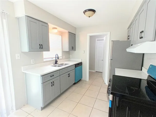 a kitchen with a sink cabinets and window