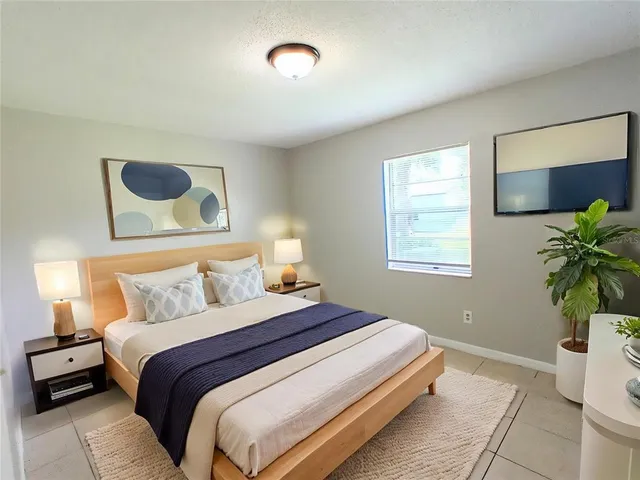 a bedroom with a bed and a potted plant