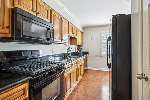 a kitchen with stainless steel appliances granite countertop a stove microwave refrigerator and sink