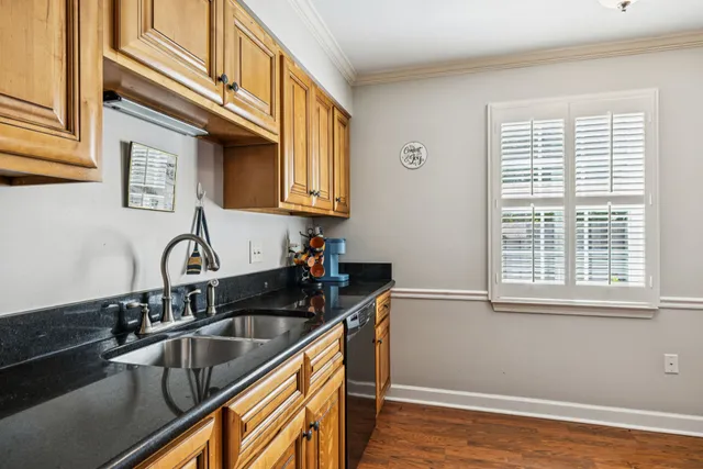 a kitchen with stainless steel appliances granite countertop a sink and a stove next to a window