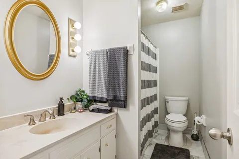 a bathroom with a toilet a sink and a mirror