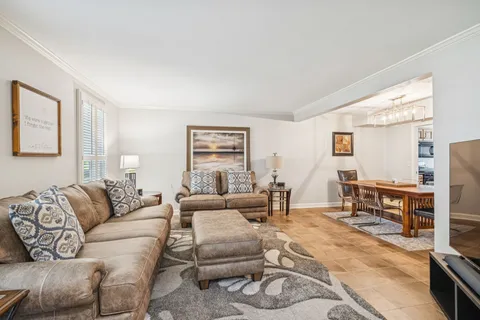 a living room with furniture a large window and a table