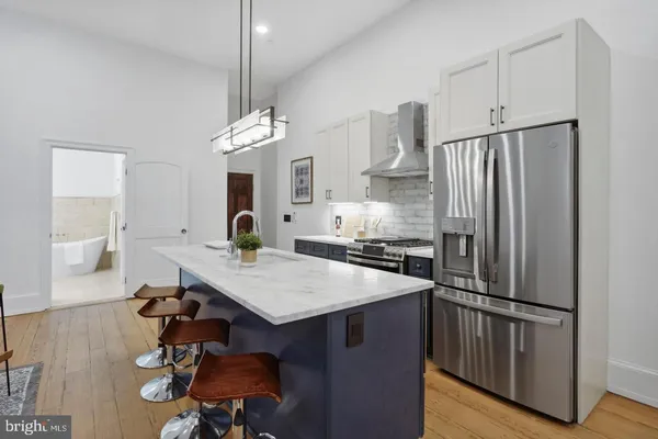 a kitchen with kitchen island a wooden floor and white appliances
