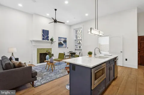 a living room with furniture a fireplace and wooden floor