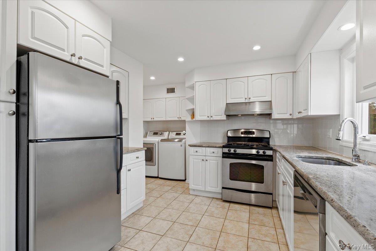 22 Old Orchard Road Rye Brook, NY 10573 - Photo 10 of 30 Kitchen with stainless steel appliances, white cabinetry, open shelves, separate washer and dryer located in a separate nook, and recessed lighting