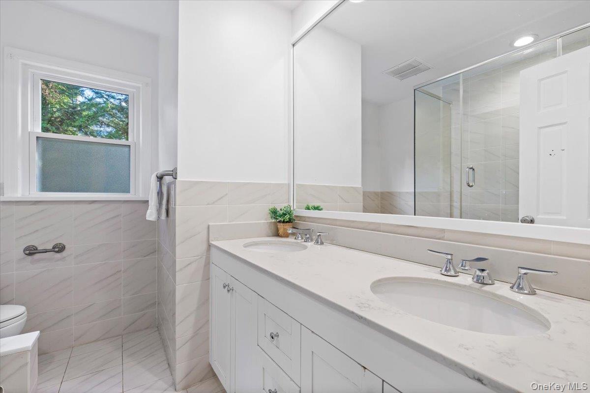 22 Old Orchard Road Rye Brook, NY 10573 - Photo 19 of 30 Hall bathroom on first floor features large dual vanity and tub/ shower w/ glass enclosure