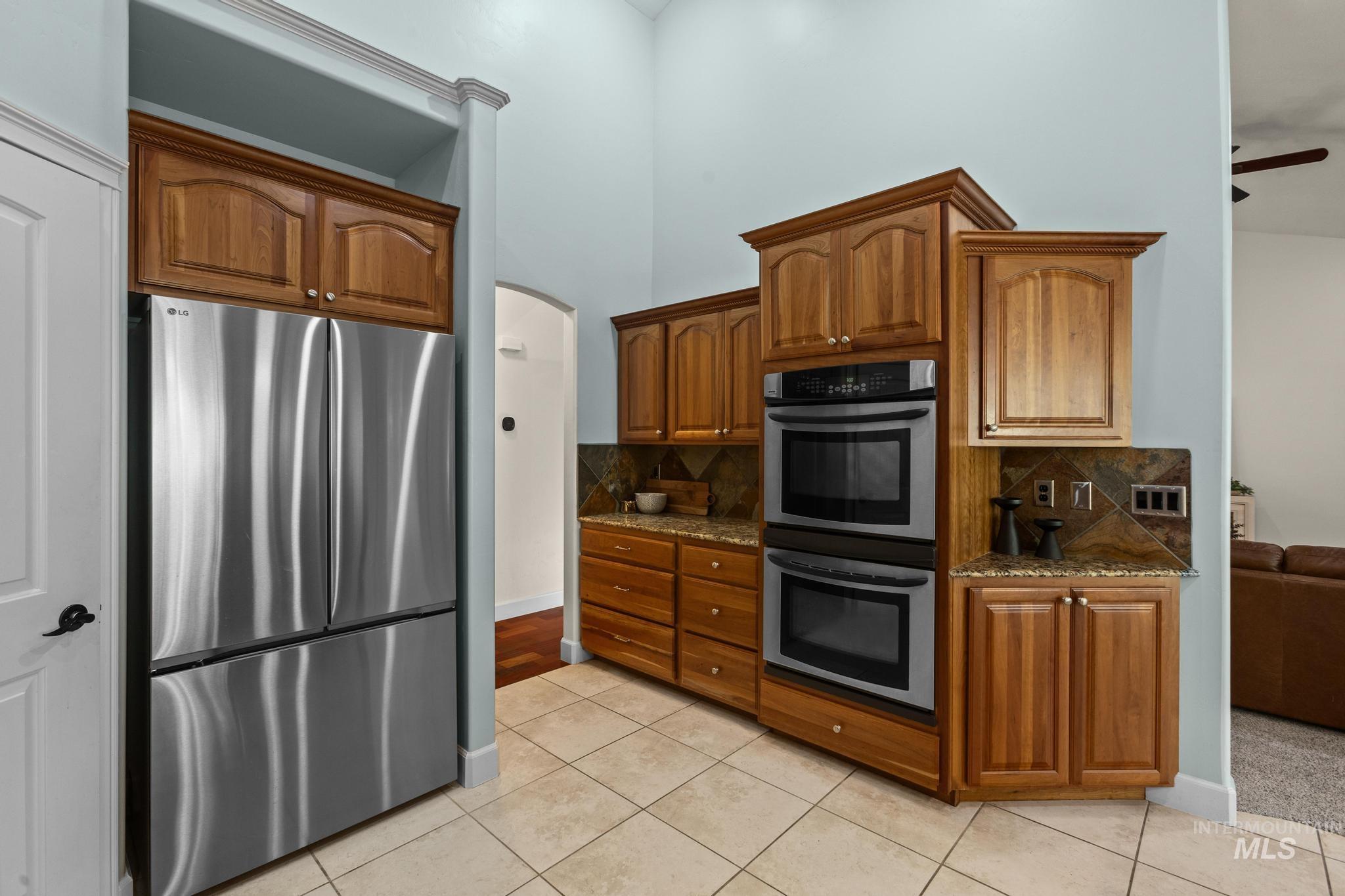 4946 North Villa Ridge Way Boise, ID 83703 - Photo 14 of 49 Kitchen featuring wood cabinetry, stainless steel appliances, granite countertops, and a tiled backsplash