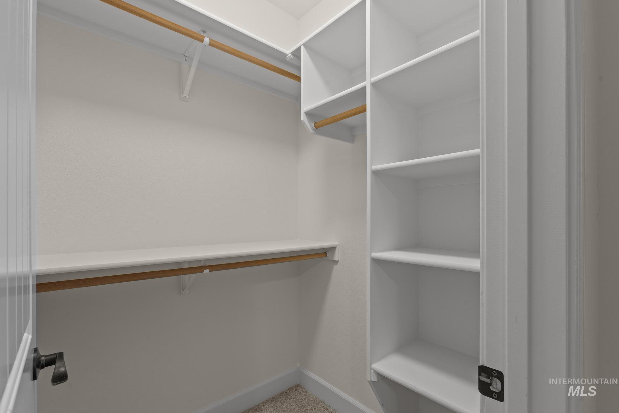 4946 North Villa Ridge Way Boise, ID 83703 - Photo 35 of 49 Custom closet system featuring white shelving and natural wood hanging rods, providing organized storage solutions