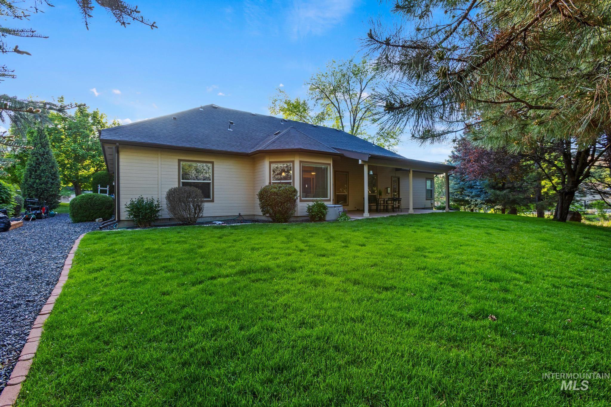 4946 North Villa Ridge Way Boise, ID 83703 - Photo 42 of 49 Spacious backyard featuring a large green lawn, mature trees, and a covered patio area with support pillars