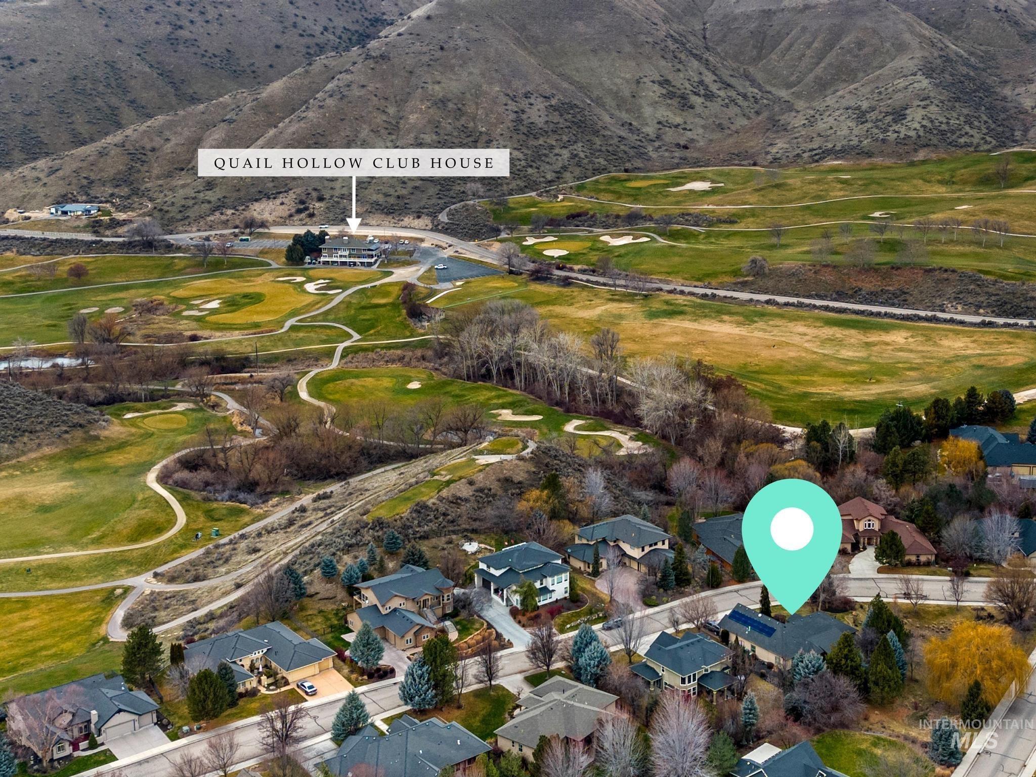 4946 North Villa Ridge Way Boise, ID 83703 - Photo 48 of 49 Aerial perspective of a residential street with homes featuring dark roofs and varied landscaping, bordered by a golf course and mountainous terrain