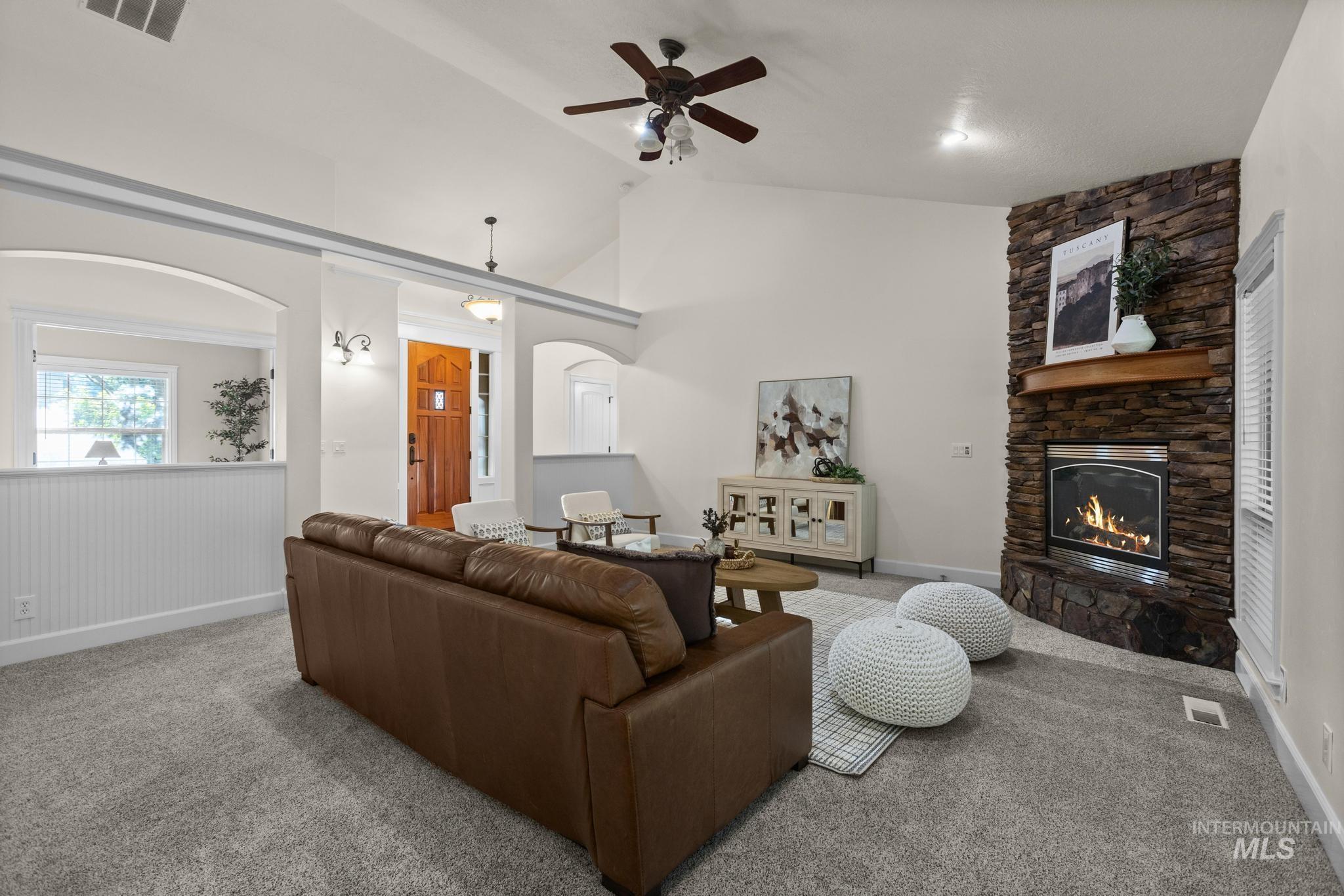 4946 North Villa Ridge Way Boise, ID 83703 - Photo 8 of 49 Living area featuring a floor-to-ceiling stone fireplace with wood mantel, vaulted ceilings, and a ceiling fan