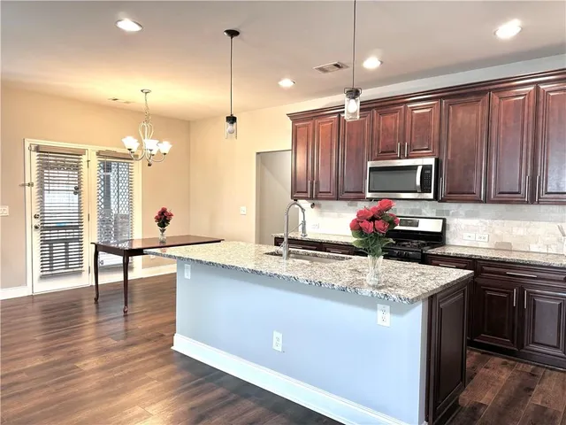 a kitchen with stainless steel appliances kitchen island granite countertop a stove refrigerator and a sink