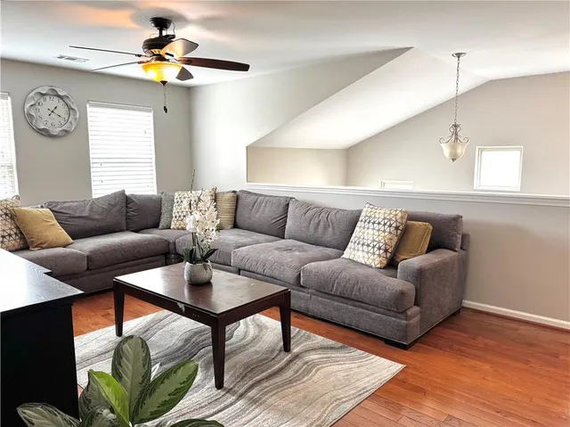 a living room with furniture and wooden floor