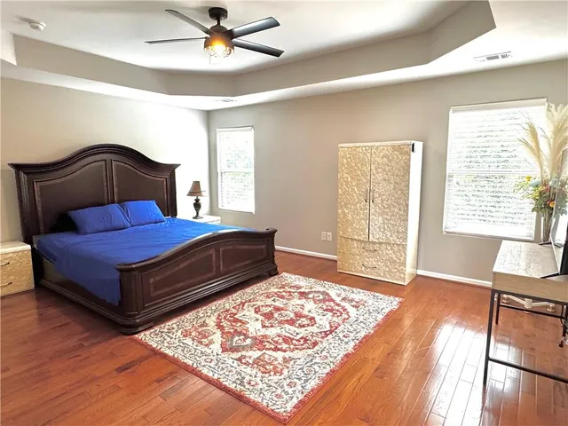 a bedroom with a bed and a flat tv screen on dresser