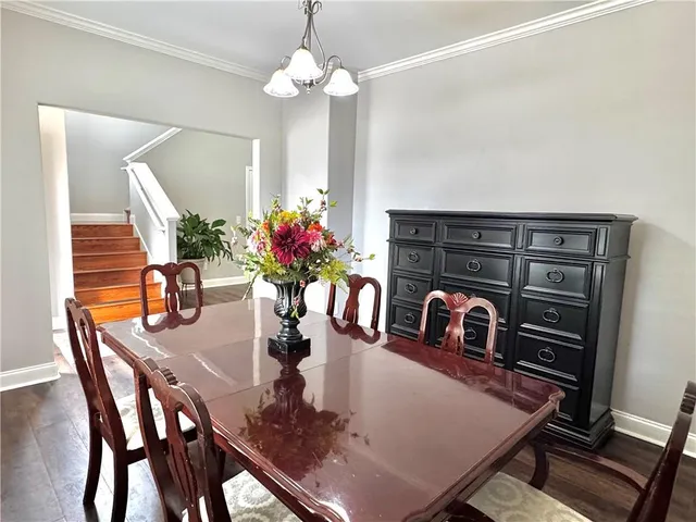 a living room with stainless steel appliances furniture and a wooden floor