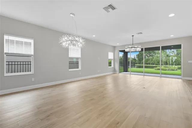 a view of a kitchen with a sink wooden floor and a chandelier