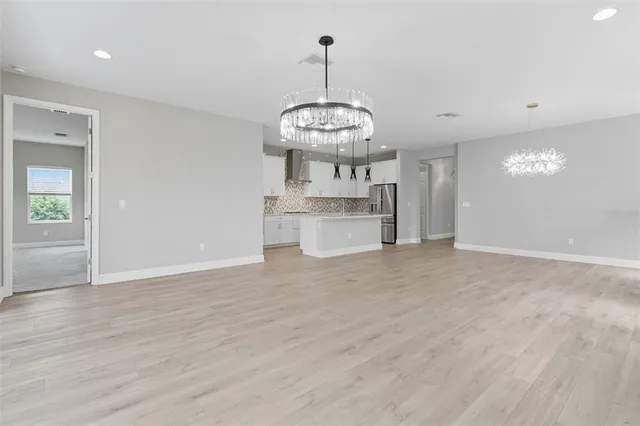 a view of kitchen with stainless steel appliances granite countertop cabinets and wooden floor