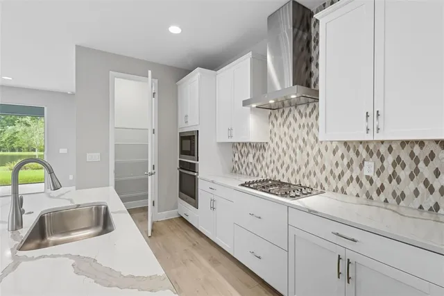 a kitchen with white cabinets and stainless steel appliances