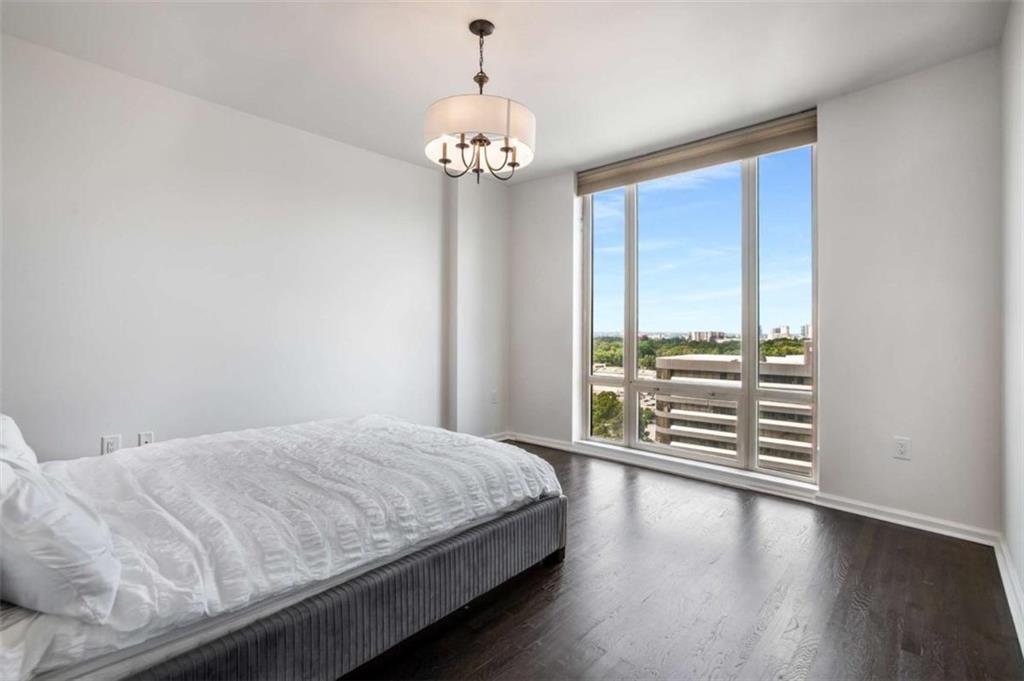 3475 Oak Valley Road Northeast, Unit 1630 Atlanta, GA 30326 - Photo 27 of 38 a bedroom with a large bed and a chandelier