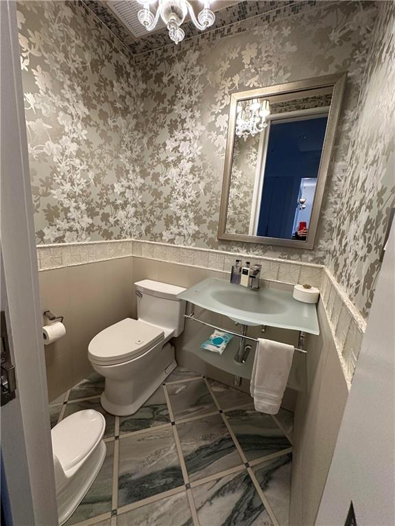 945 East 10th Street Brooklyn, NY 11230 - Photo 14 of 21 a bathroom with a toilet a sink and mirror
