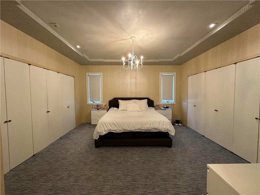 945 East 10th Street Brooklyn, NY 11230 - Photo 17 of 21 a spacious bedroom with a bed and a chandelier