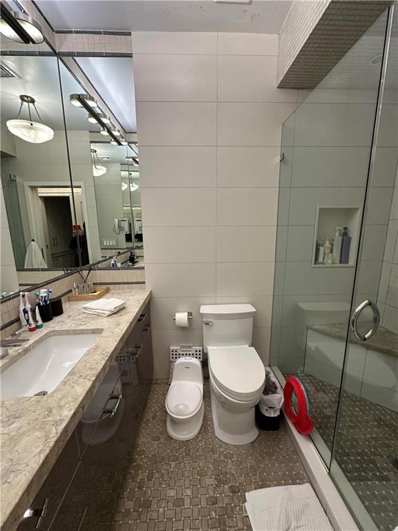 945 East 10th Street Brooklyn, NY 11230 - Photo 19 of 21 a bathroom with a granite countertop sink mirror vanity and toilet
