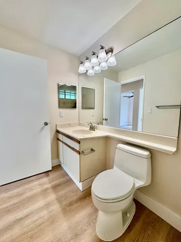 a bathroom with a white toilet sink and mirror