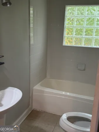 a bathroom with a toilet and a bath tub