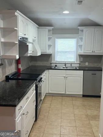 a kitchen with stainless steel appliances granite countertop a sink stove and cabinets