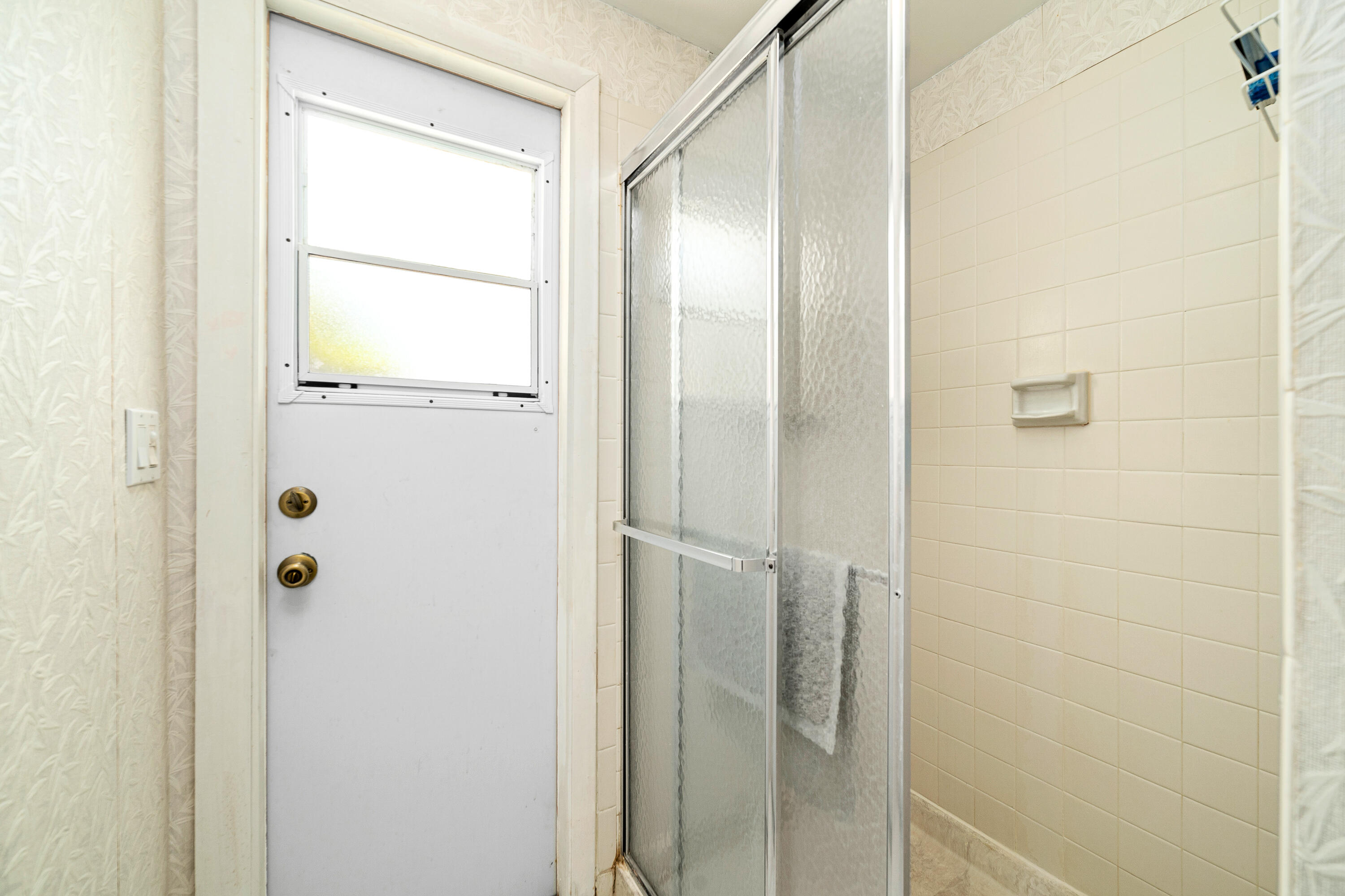 1801 Us Highway, Unit 18D Jupiter, FL 33477 - Photo 25 of 36 a bathroom with a glass shower door
