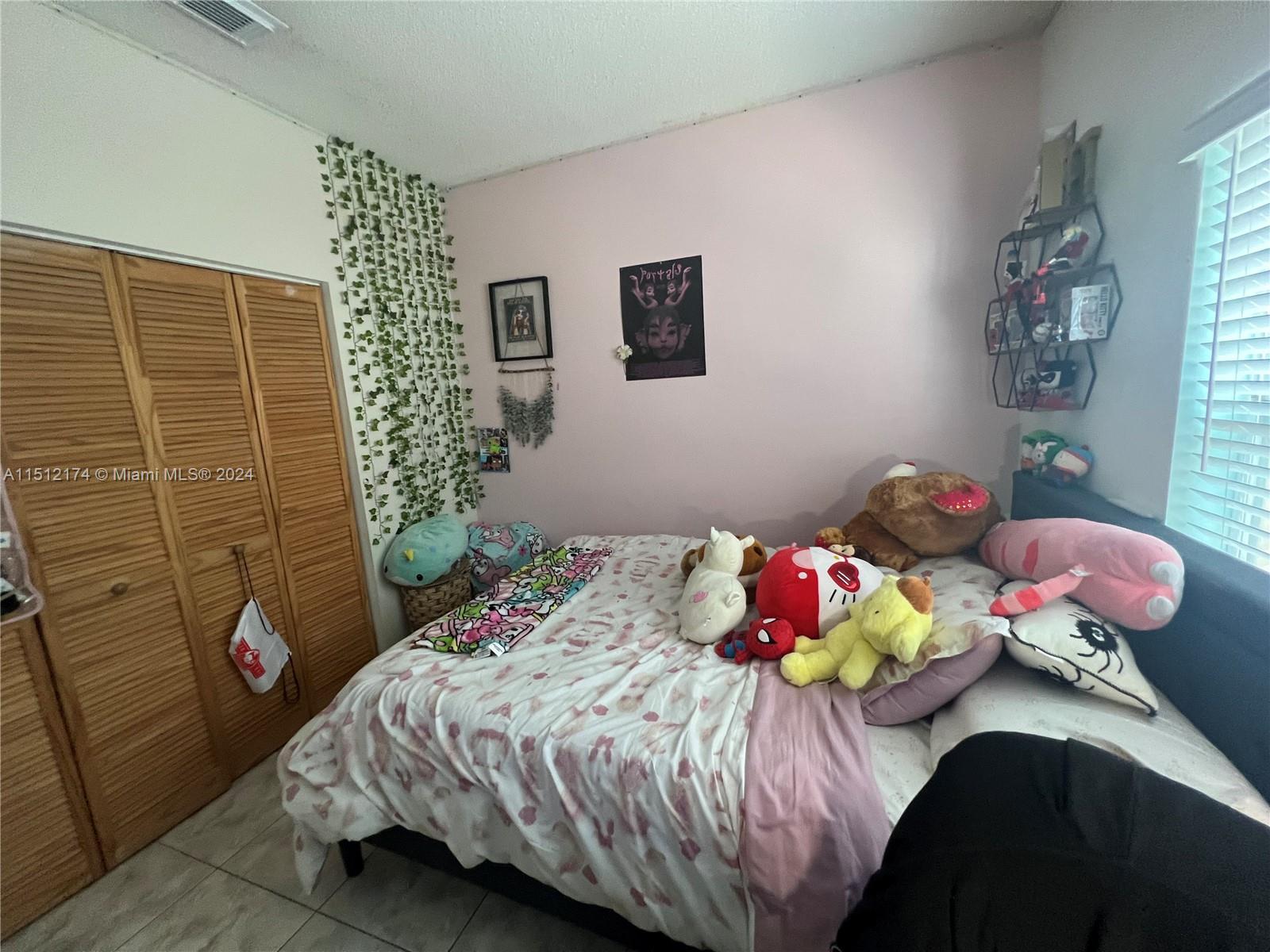 8118 Northwest 200th Street Hialeah, FL 33015 - Photo 19 of 24 a bedroom with a bed and a potted plant
