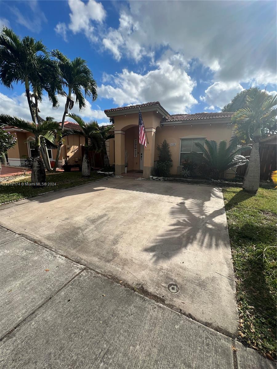 8118 Northwest 200th Street Hialeah, FL 33015 - Photo 2 of 24 a front view of a house with a yard and garage