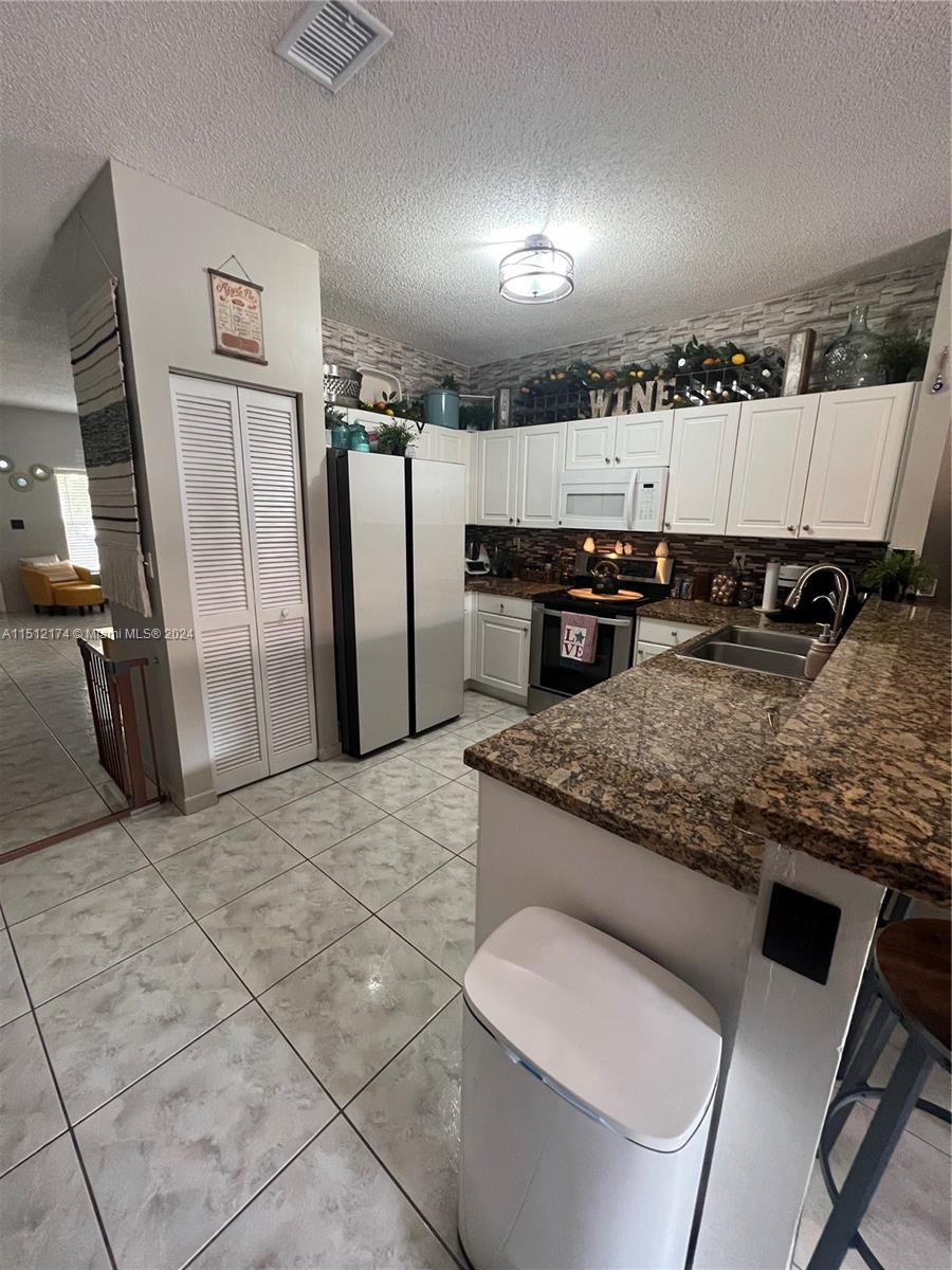 8118 Northwest 200th Street Hialeah, FL 33015 - Photo 3 of 24 a kitchen with stainless steel appliances granite countertop a sink stove and refrigerator