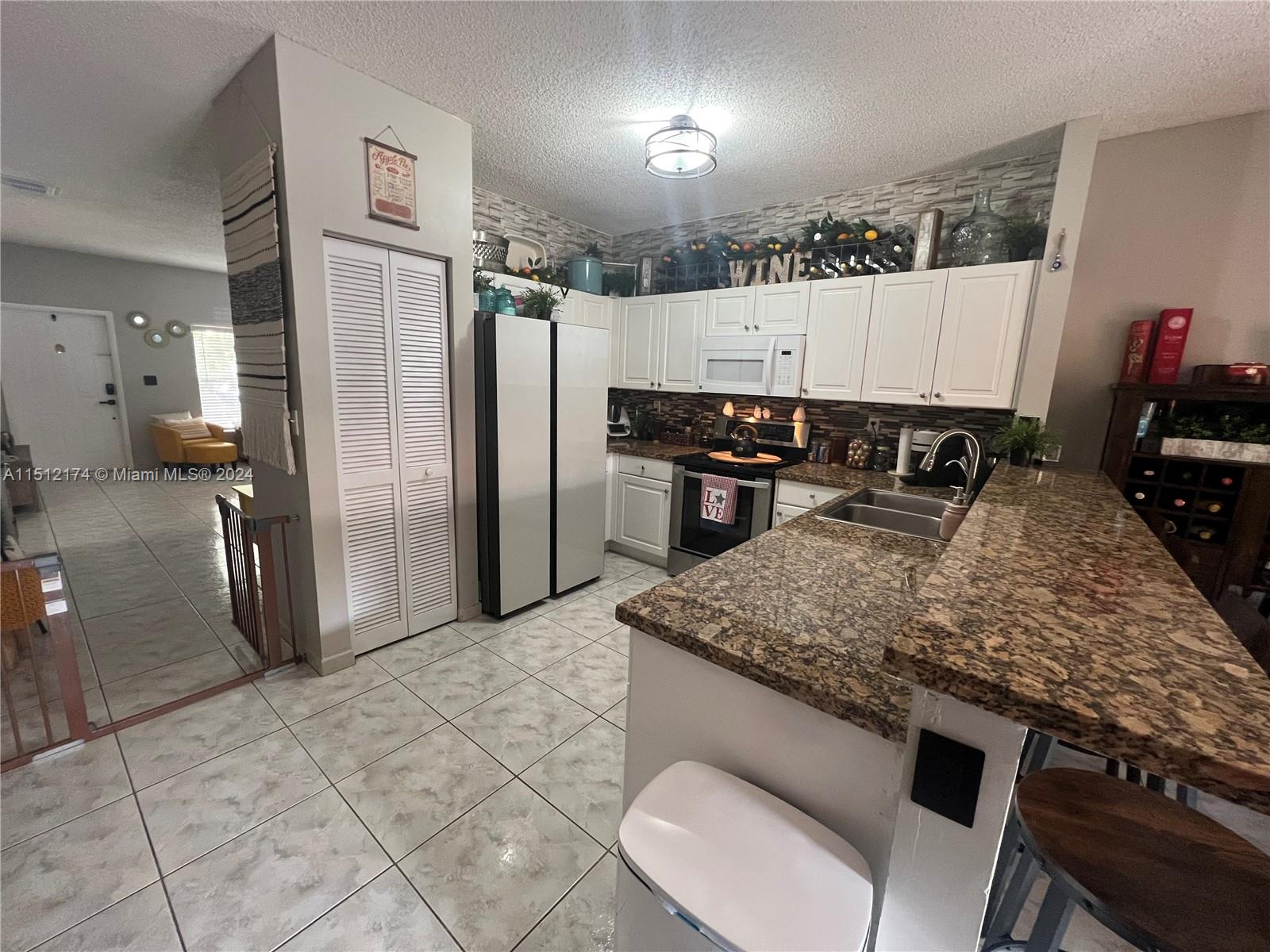 8118 Northwest 200th Street Hialeah, FL 33015 - Photo 4 of 24 a kitchen with stainless steel appliances granite countertop a sink stove and refrigerator