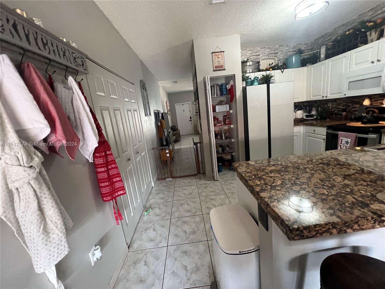 8118 Northwest 200th Street Hialeah, FL 33015 - Photo 5 of 24 a kitchen with white cabinets and stainless steel appliances