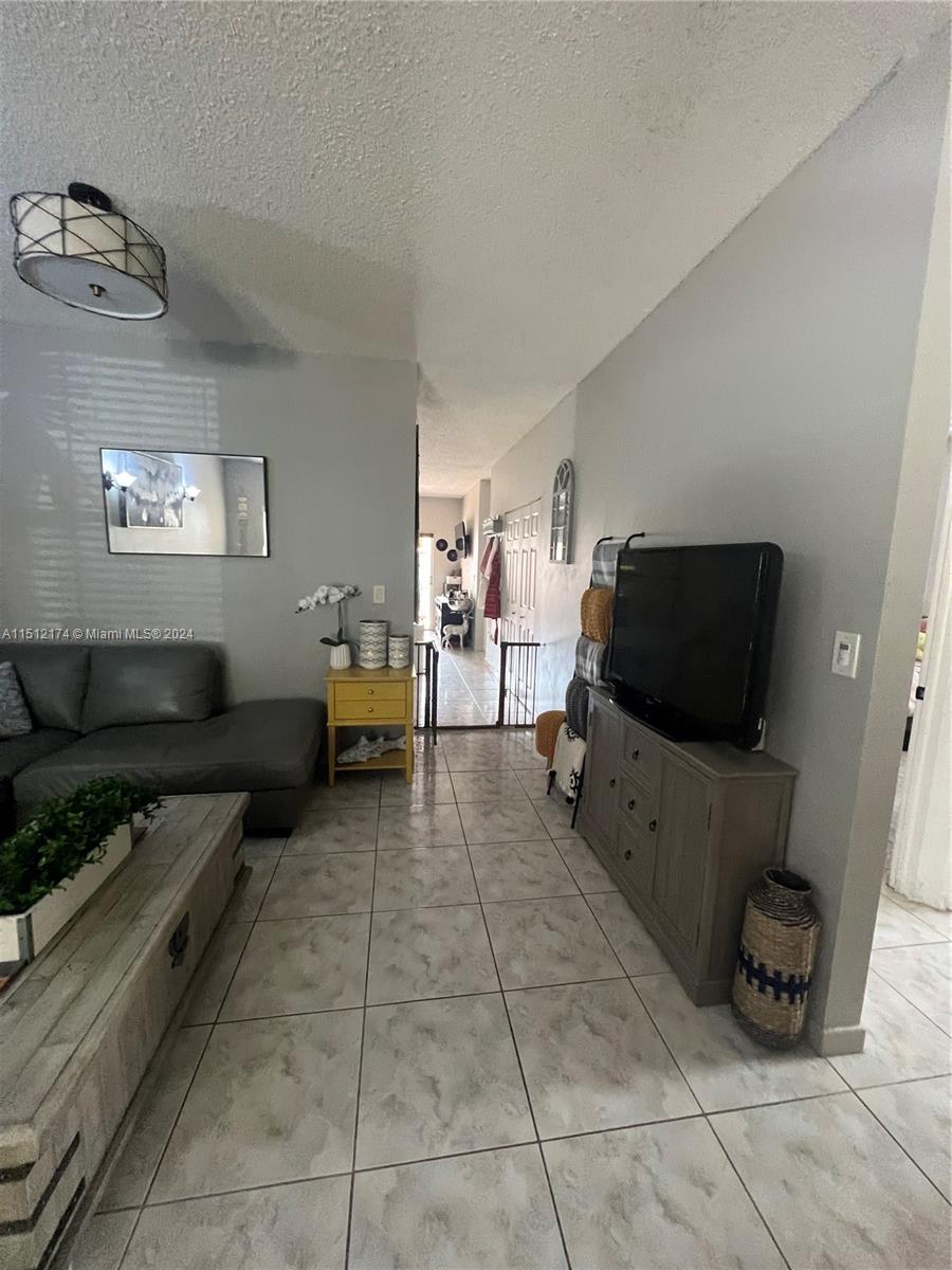 8118 Northwest 200th Street Hialeah, FL 33015 - Photo 10 of 24 a living room with furniture and a flat screen tv