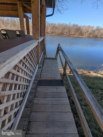 a view of balcony with wooden floor and potted plants