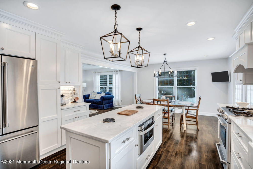 5 Cedar Drive Colts Neck, NJ 07722 - Photo 12 of 41 a kitchen that has a lot of stainless steel appliances and wooden floor