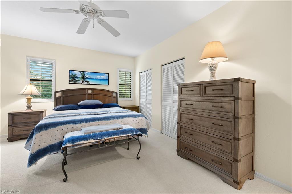 6500 Valen Way, Unit A203 Naples, FL 34108 - Photo 6 of 18 Bedroom with ceiling fan, baseboards, two closets, and light carpet