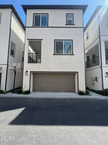 a patio with a table and chairs and potted plants