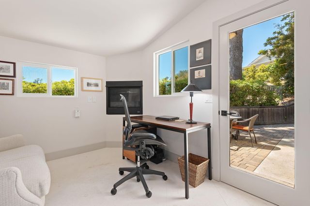 a view of a workspace with furniture and a window