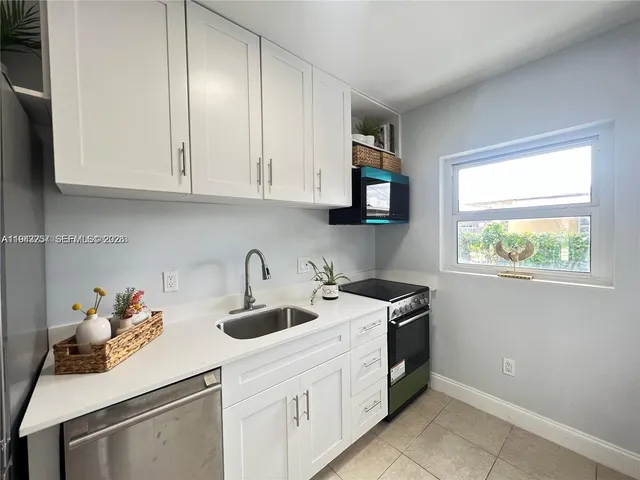a kitchen with white cabinets and a sink