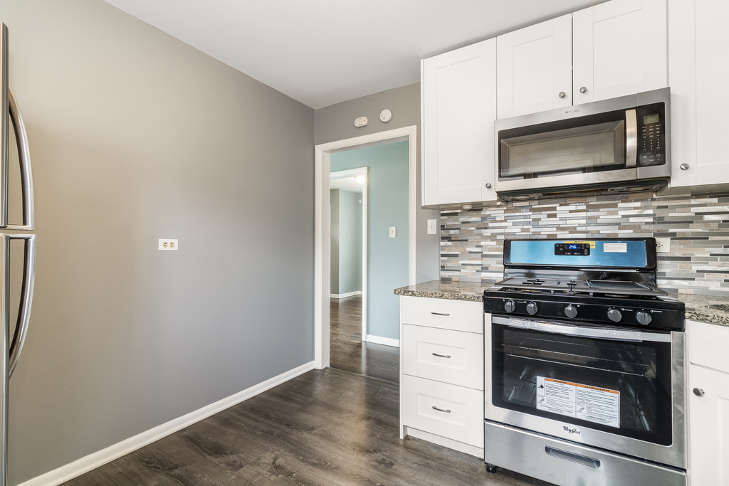 466 East Butterfield Road Elmhurst, IL 60126 - Photo 6 of 11 a kitchen with granite countertop a stove and a microwave